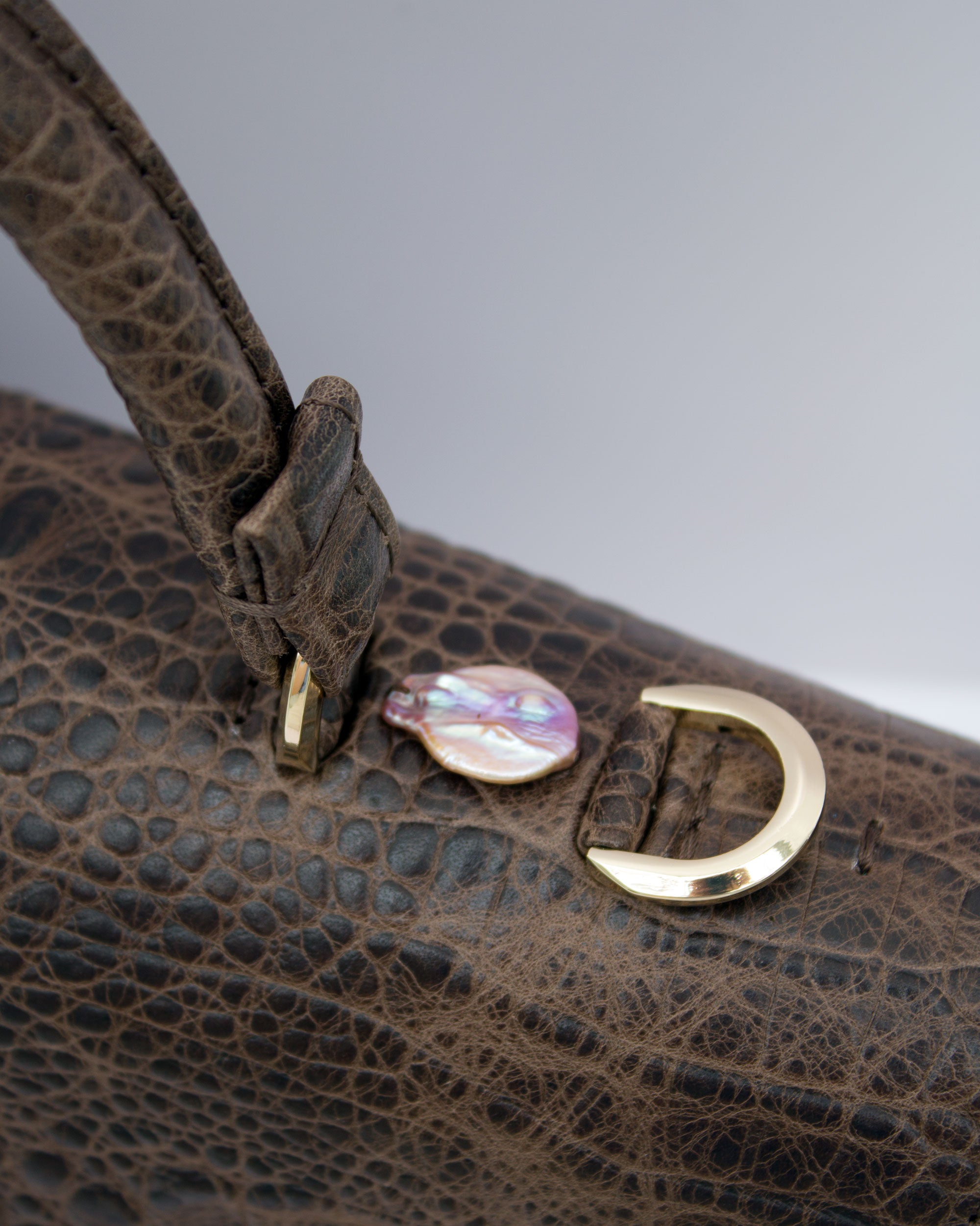 "Audrey Baguette" skóra tłoczona na wzór krokodyla z różową perłą słodkowodną. Dostępna w kilku kolorach